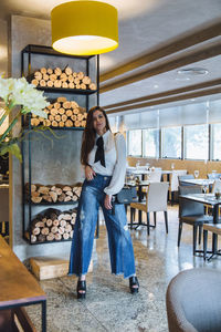 Portrait of woman standing in illuminated cafe