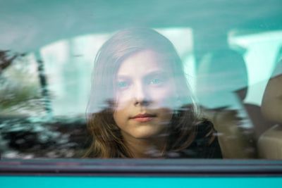 Portrait of boy looking through car window