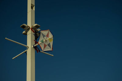 Low angle view of windmill against clear blue sky