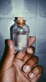 Close-up of human hand holding glass bottle