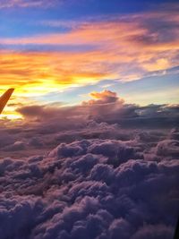 Aerial view of clouds over landscape during sunset