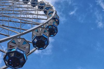 Low angle view of ferris wheel against blue sky