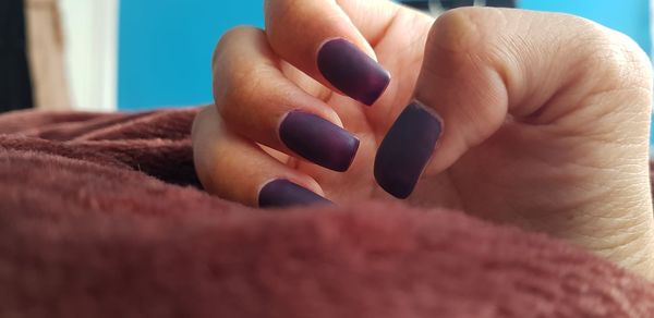 Close-up of woman with purple fingernails