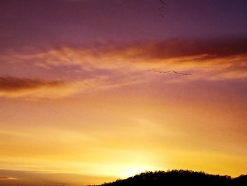 Low angle view of silhouette landscape against sky during sunset