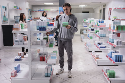 Full length of young woman standing in store