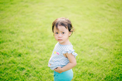 Portrait of cute girl standing on field