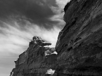 Low angle view of rock formation amidst buildings against sky