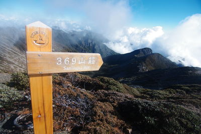 Information sign on mountain against sky