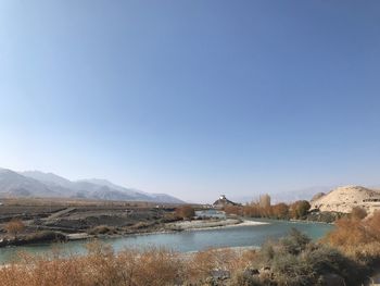 Scenic view of lake against clear blue sky