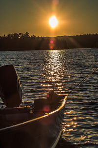 Cropped image of boat in sea at sunset