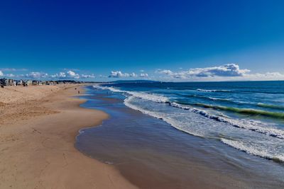 Scenic view of beach against blue sky