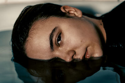 Close-up portrait of young woman in bathtub