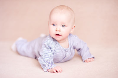 Cute baby boy against beige background