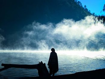 Rear view of silhouette man looking at sea against sky
