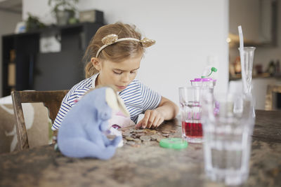 Girl counting savings on table