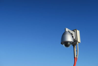 Low angle view of electric lamp against clear blue sky