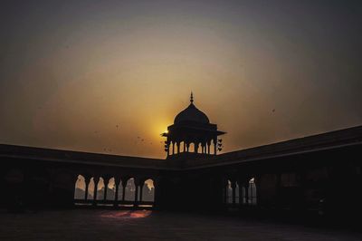 Silhouette of building against sky during sunset