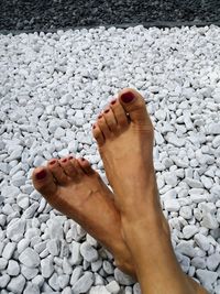 Low section of woman on pebbles