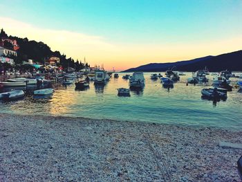 Boats in sea at sunset