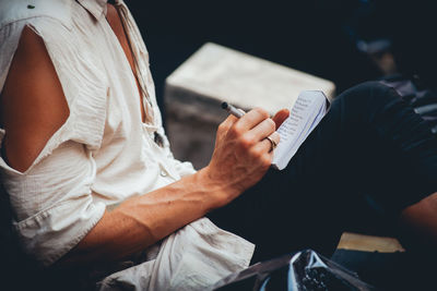 Midsection of man using mobile phone