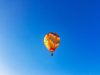 Low angle view of hot air balloon against clear blue sky