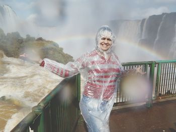 Portrait of female tourist wearing raincoat at iguacu falls