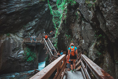 People on footbridge in forest