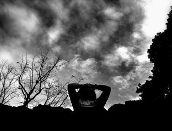 Rear view of silhouette woman against bare tree