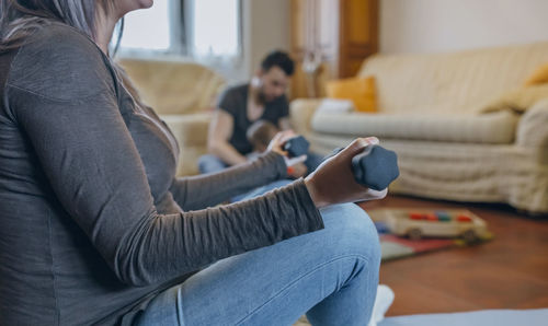 Close-up of woman using mobile phone while sitting on sofa at home