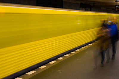 Blurred motion of people walking on railroad station platform