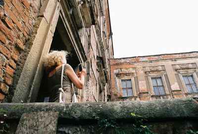 Low angle view of woman against built structure