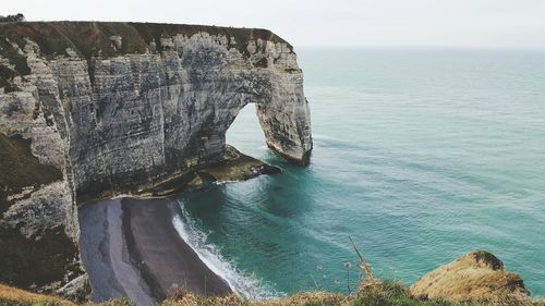 Rock formation in sea against sky