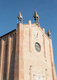 Low angle view of clock tower amidst buildings against sky