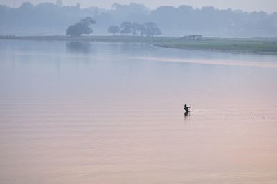 Man swimming in lake against sky