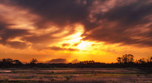 Scenic view of silhouette landscape against orange sky