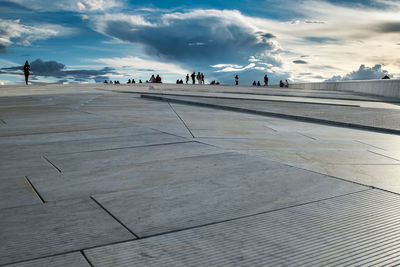 Surface level view of people at oslo opera house against sky