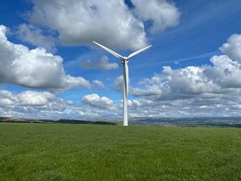 Windmill on field against sky