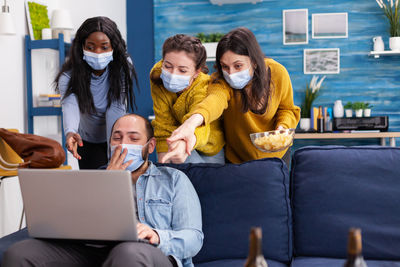 People wearing mask looking at laptop