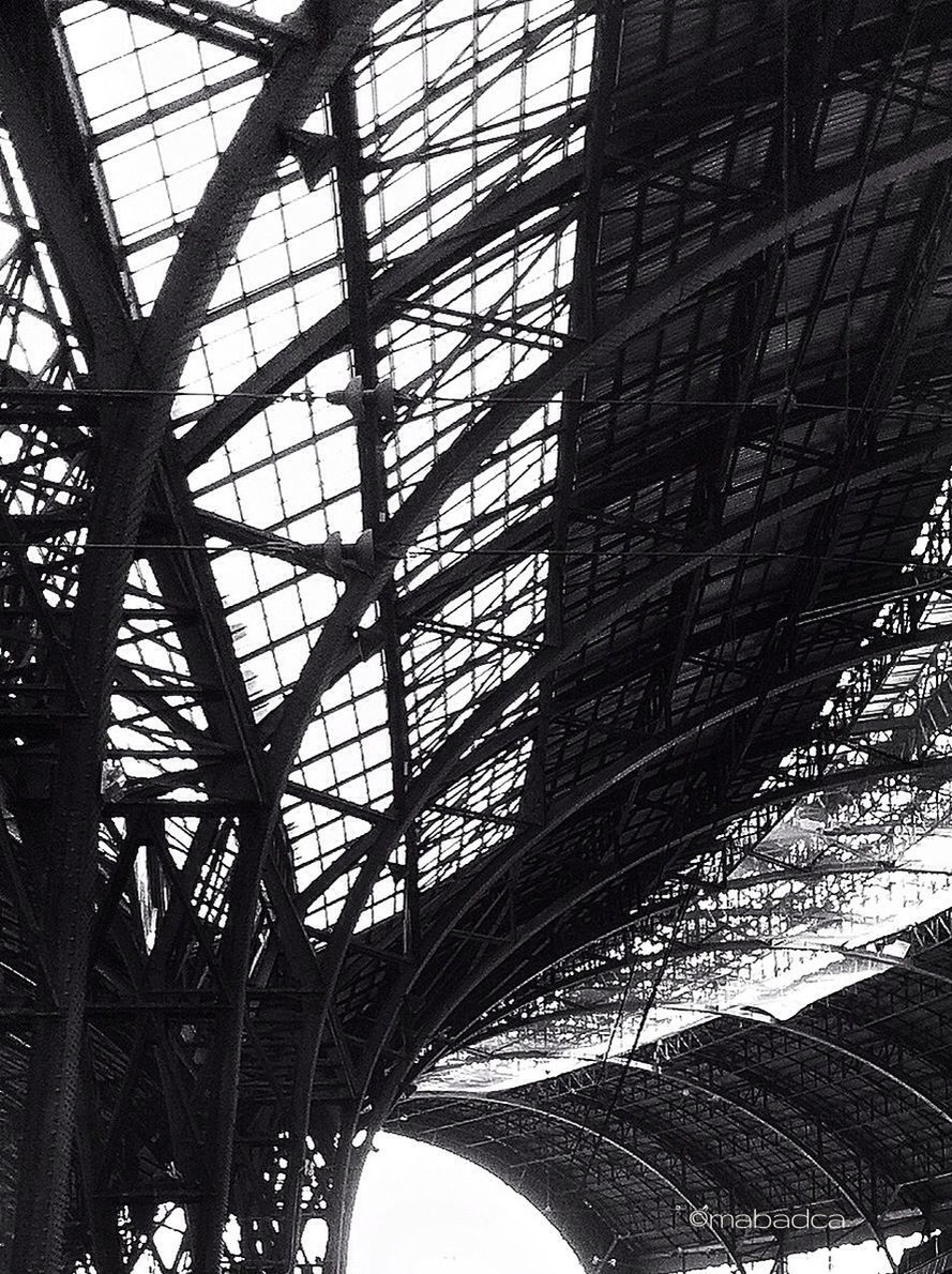 low angle view, built structure, architecture, metal, metallic, pattern, architectural feature, indoors, grid, directly below, ceiling, day, design, no people, sky, clear sky, building exterior, engineering, modern