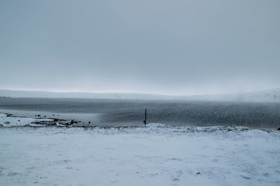 Scenic view of snow covered land against sky