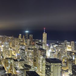 Illuminated cityscape against sky at night