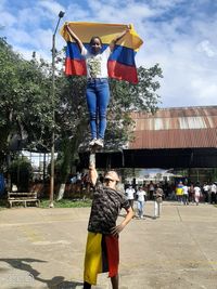 Full length of woman jumping in park against sky