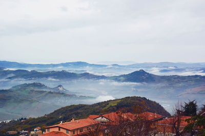 Scenic view of townscape and mountains against sky