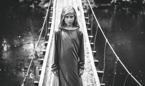 Portrait of girl standing on rope bridge