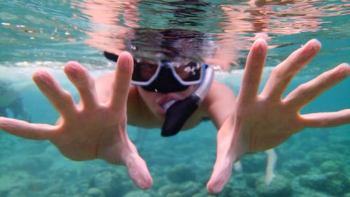 Man wearing snorkel swimming undersea