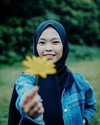 Portrait of smiling young woman standing on field