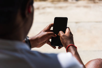 Midsection of man using mobile phone