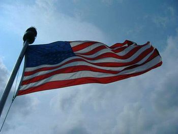 Low angle view of american flag against blue sky