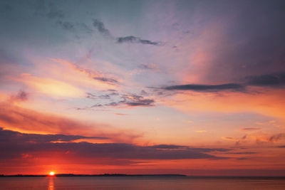 Scenic view of sea against dramatic sky during sunset