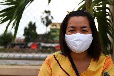 Portrait of woman wearing mask sitting outdoors